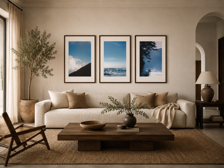 A modern living room with a triptych style gallery wall with calming fine art prints above the sofa