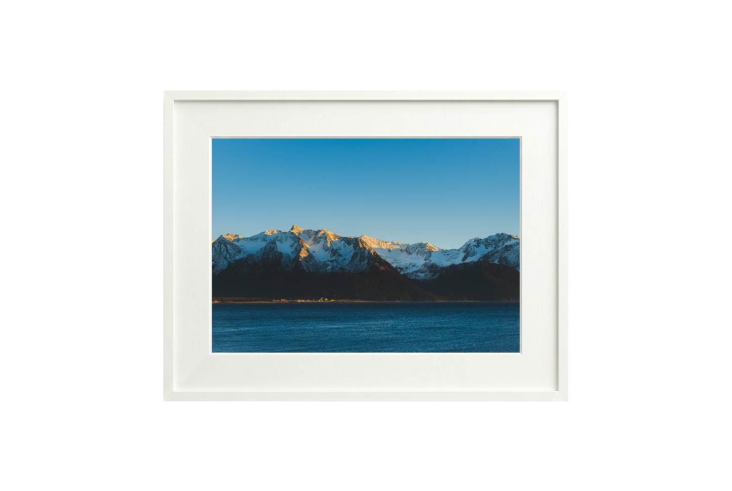 Framed photograph of a mountain landscape with a blue sky.