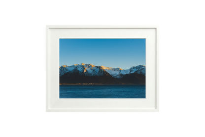 Framed photograph of a mountain landscape with a blue sky.