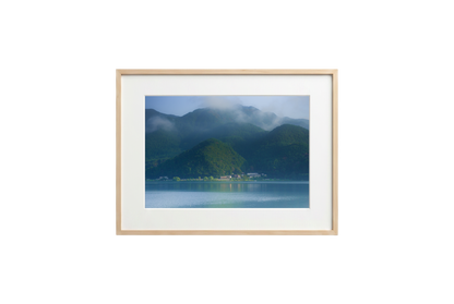 Framed photograph of a mountain landscape with a lake on a black background