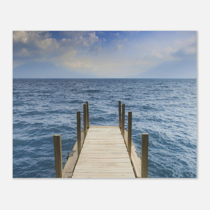 Framed photograph of a dock extending into the ocean on a white wall.