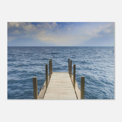 Framed photograph of a dock extending into the ocean on a white wall.
