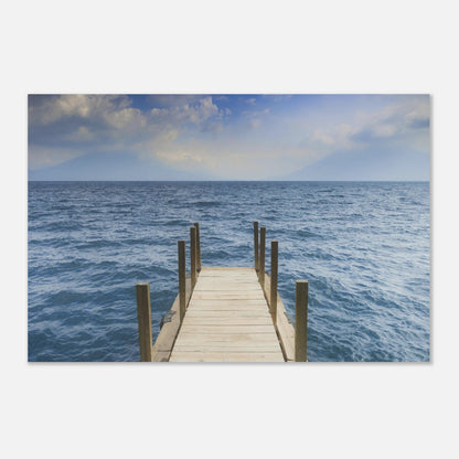 Framed photograph of a dock extending into the ocean on a white wall.