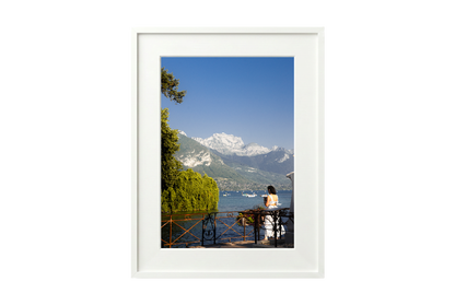 Framed photograph of a scenic view with mountains and a lake.