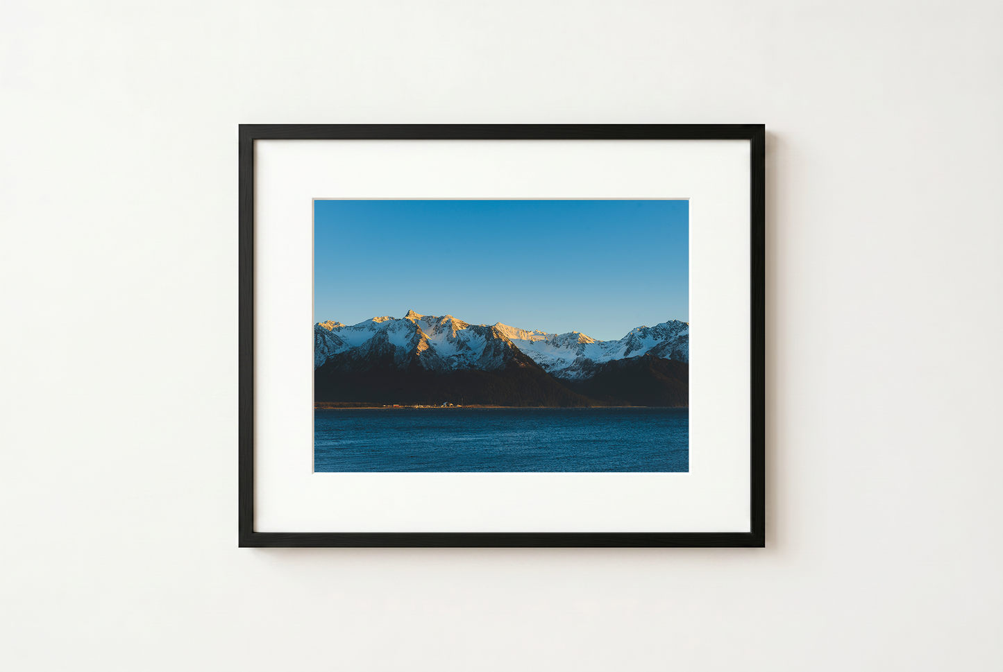 Framed photograph of a mountain landscape with a blue sky.
