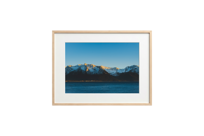 Framed photograph of a mountain landscape with a blue sky.