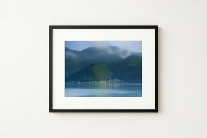 Framed photograph of a mountain landscape on a white wall
