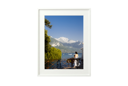 Framed photograph of a scenic view with mountains and a lake.