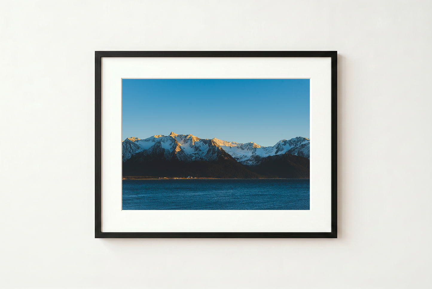 Framed photograph of a mountain landscape with a blue sky.