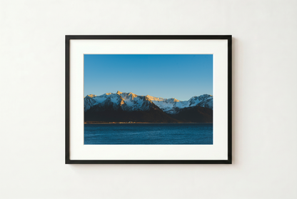 Framed photograph of a mountain landscape with a blue sky.