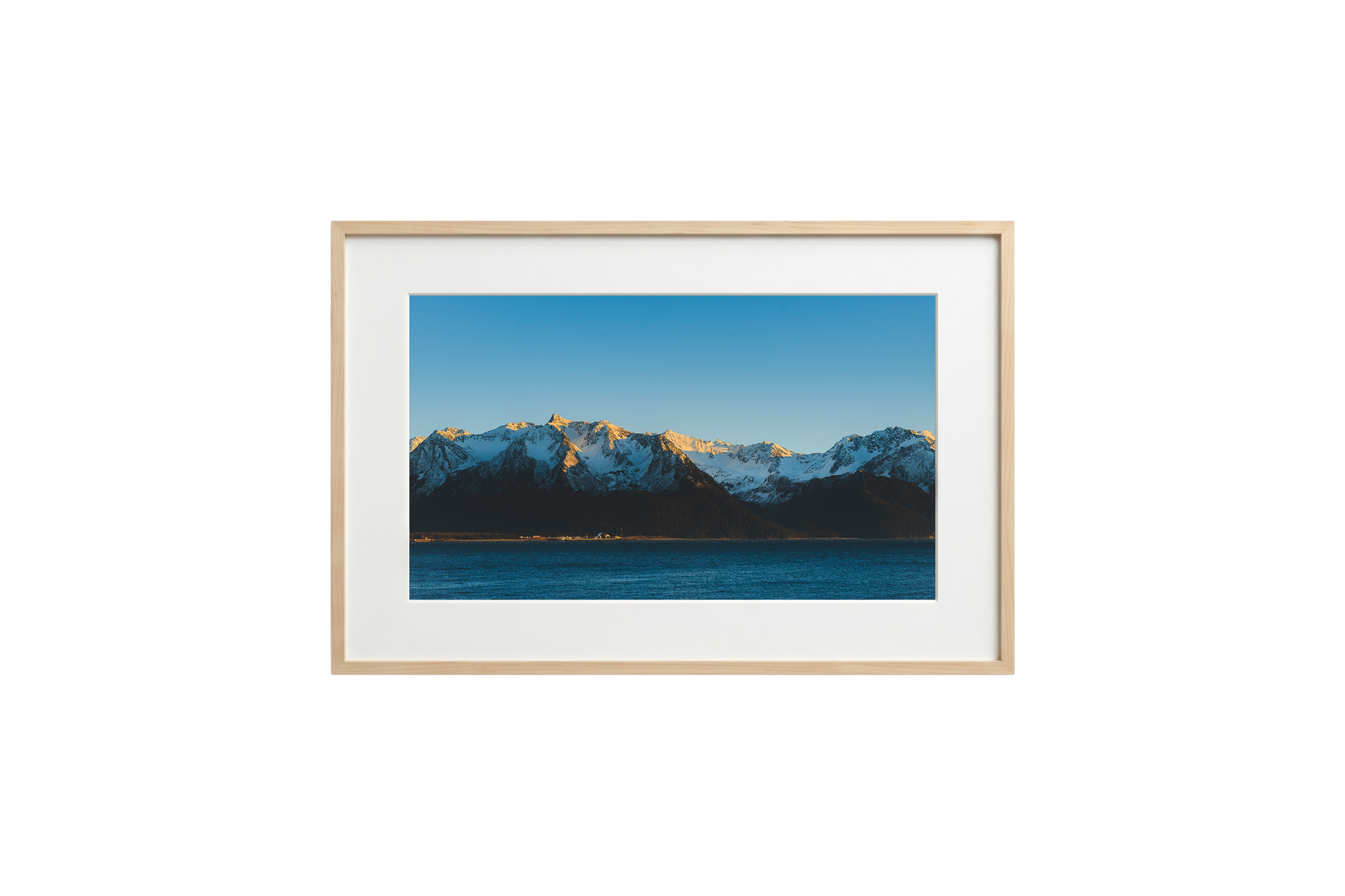 Framed photograph of a mountain landscape with snow-capped peaks and a clear blue sky.
