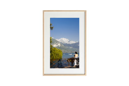 Framed photograph of a scenic view with mountains and a lake.