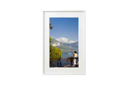 Framed photograph of a scenic view with mountains and a lake.