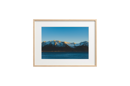 Framed photograph of a mountain landscape with a blue sky.