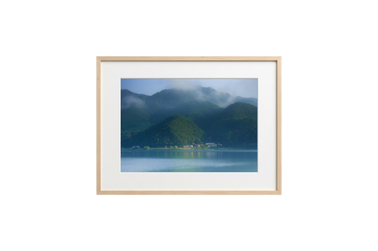 Framed photograph of a mountain landscape with a lake on a black background