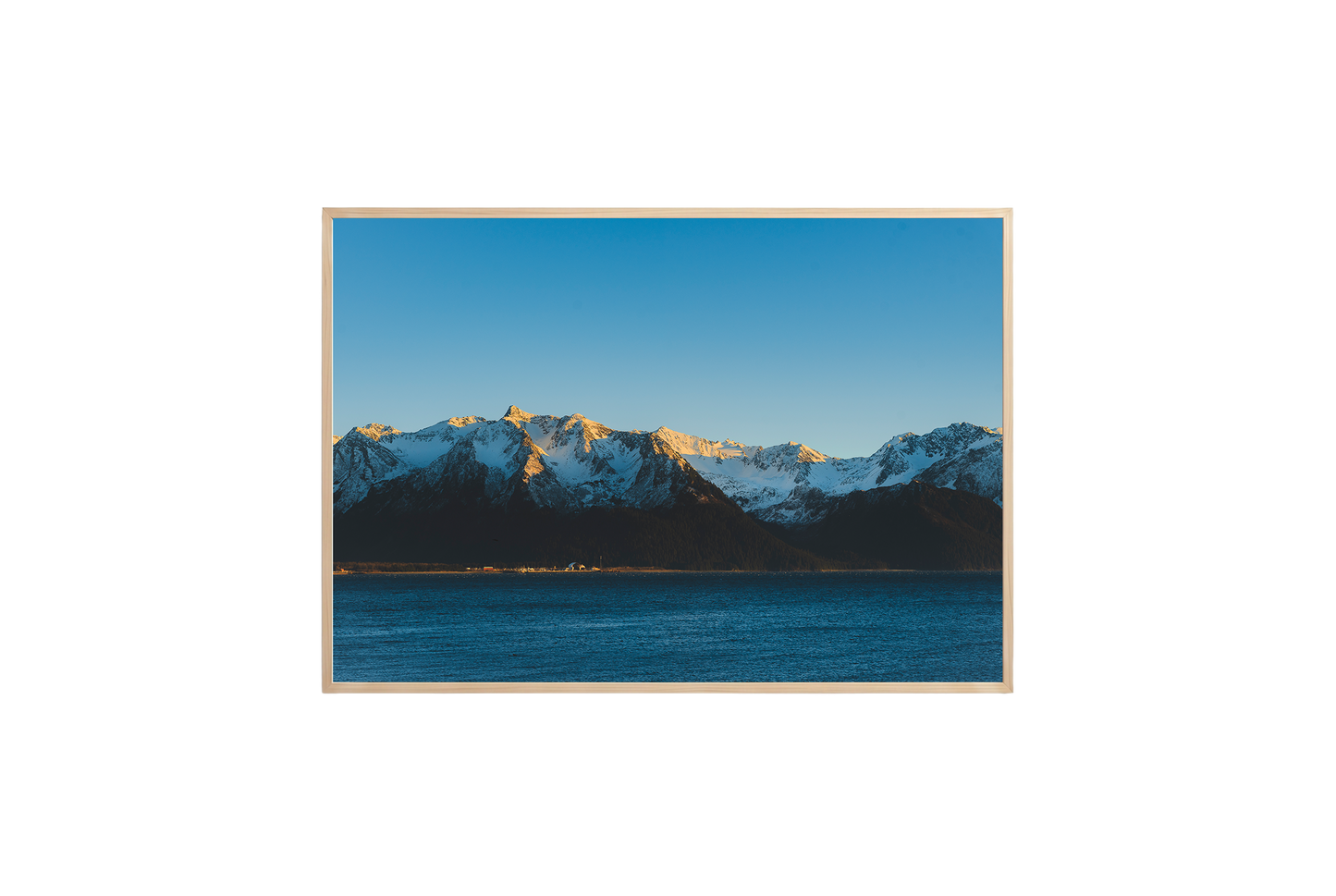 Framed photograph of a mountain range with snow and a blue sky.