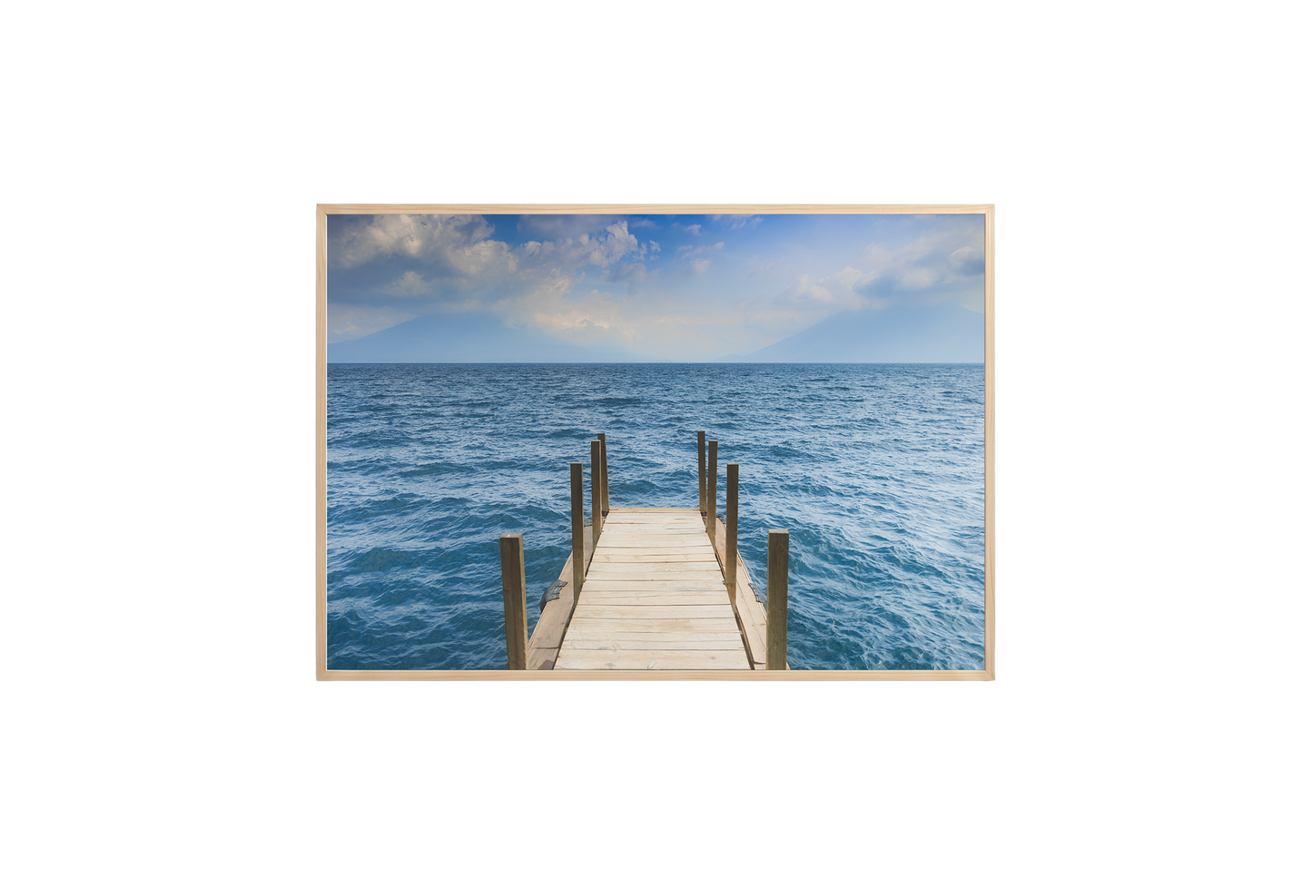 Framed photograph of a dock extending into the ocean on a white wall.
