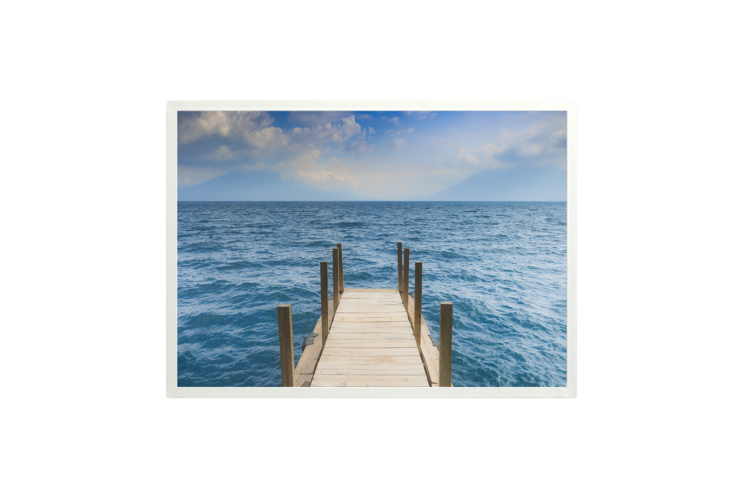 Framed photograph of a dock extending into the ocean on a white wall.