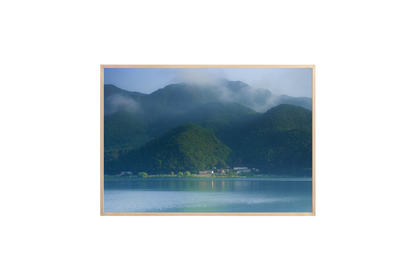 Scenic view of mountains and a lake with a wooden frame.