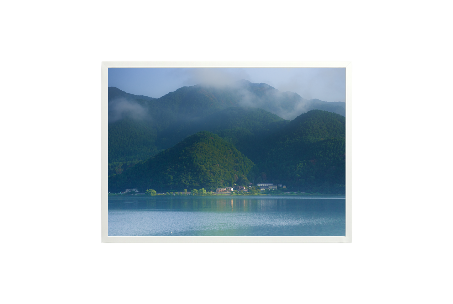 Mountain landscape with a lake and misty mountains in the background