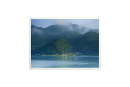 Mountain landscape with a lake and misty mountains in the background