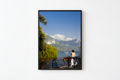Framed photograph of a person by a lake with mountains in the background