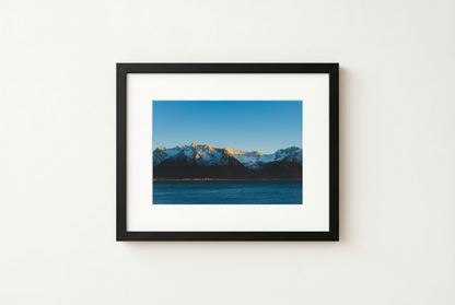 Framed photograph of a mountain landscape with a blue sky.