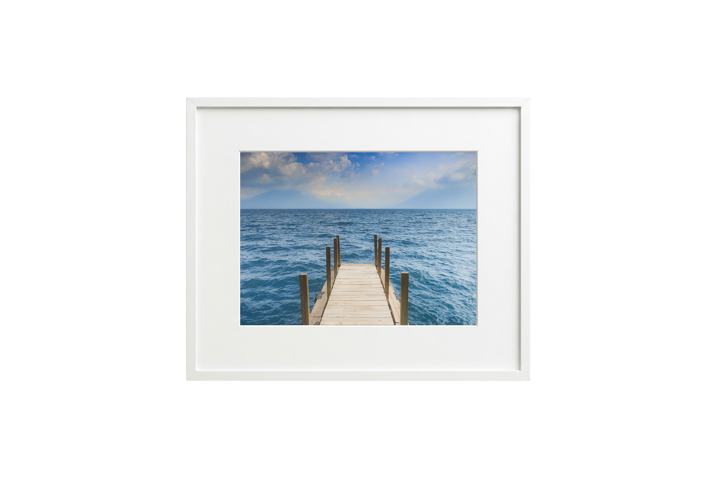 Framed picture of a wooden dock extending into the ocean with a white frame.