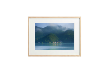 Framed photograph of a mountain landscape with a lake on a black background
