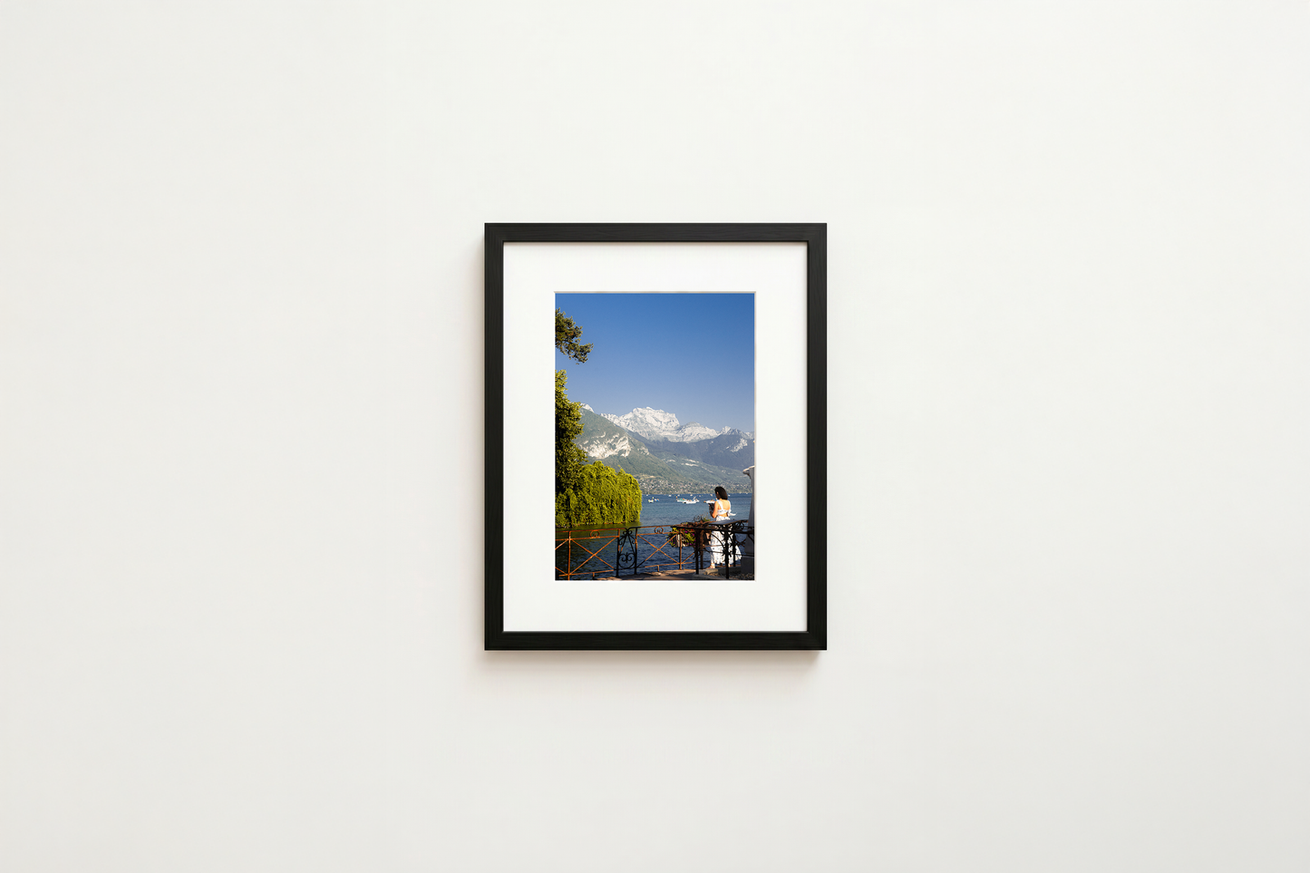 Framed photograph of a scenic view with mountains on a white wall