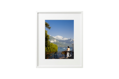 Framed photograph of a scenic view with mountains and a lake.