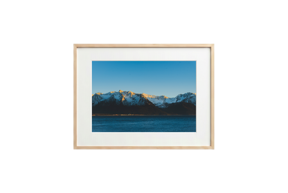 Framed photograph of a mountain landscape with a blue sky.