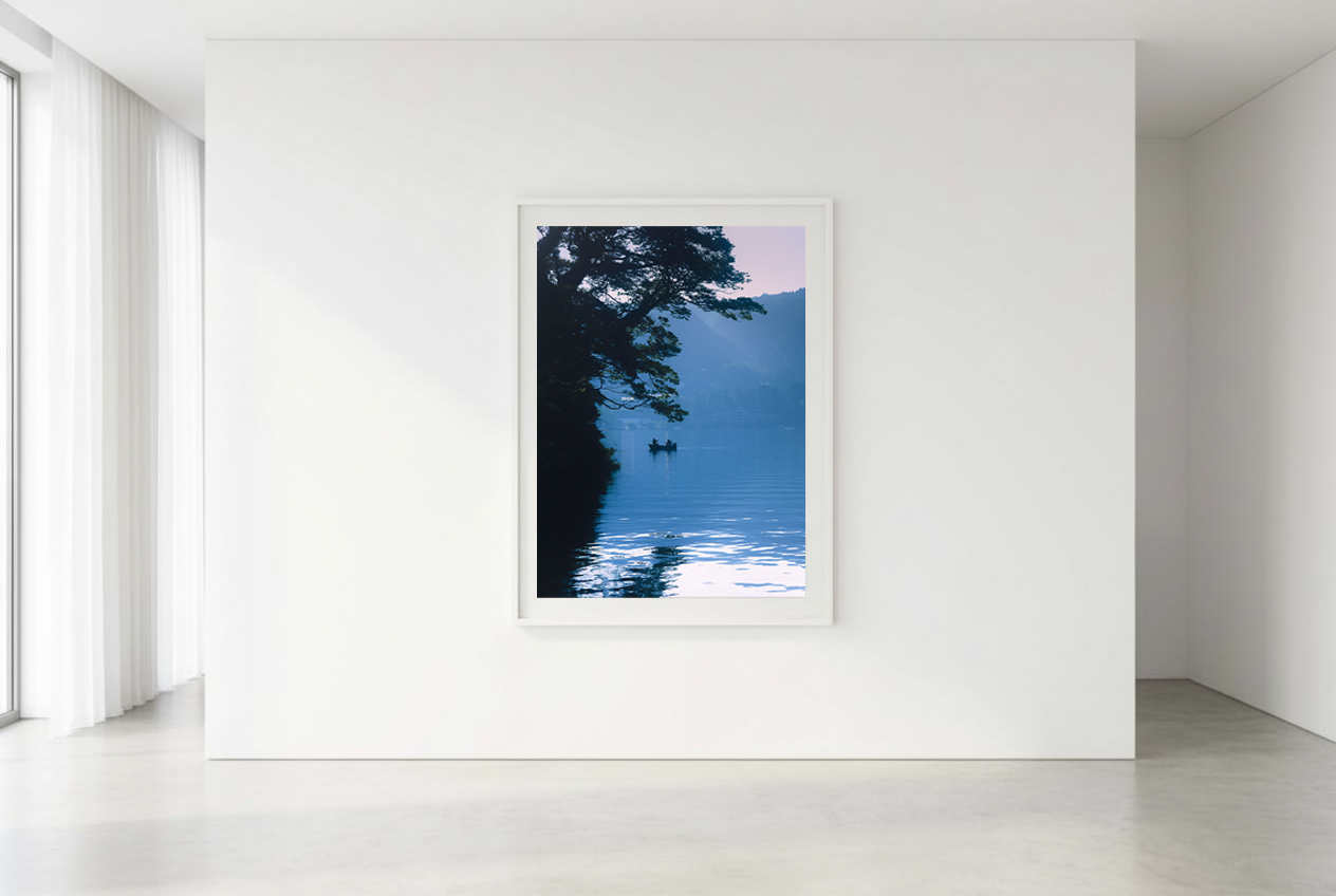 This minimalist lake photography print features a serene blue-toned landscape with a boat silhouette, making it perfect for calm wall art, Japandi decor, and modern minimalist interiors. Ideal for bedrooms, living rooms, and offices, this premium fine art print brings a peaceful, reflective atmosphere through soft blue hues and natural composition.