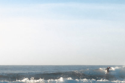 This minimalist ocean photography print features a serene blue seascape with a distant surfer, making it ideal for coastal wall art, calm interior design, and modern minimalist decor. Designed for those seeking premium fine art prints with soft blue tones, it enhances living rooms, bedrooms, and office spaces with a sense of tranquility and refined simplicity.