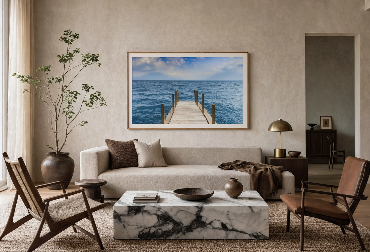 Living room with a framed photograph of a dock extending into blue water above the sofa