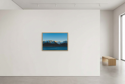 This calming mountain and ocean wall art print features a minimalist landscape with blue tones and soft natural light. Perfect for modern, coastal, or Scandinavian-inspired interiors, it brings a peaceful atmosphere to any space.