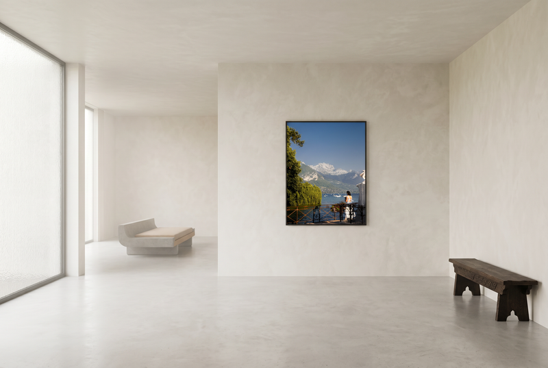 Modern interior with a large window and a wall-mounted painting of a mountain landscape.