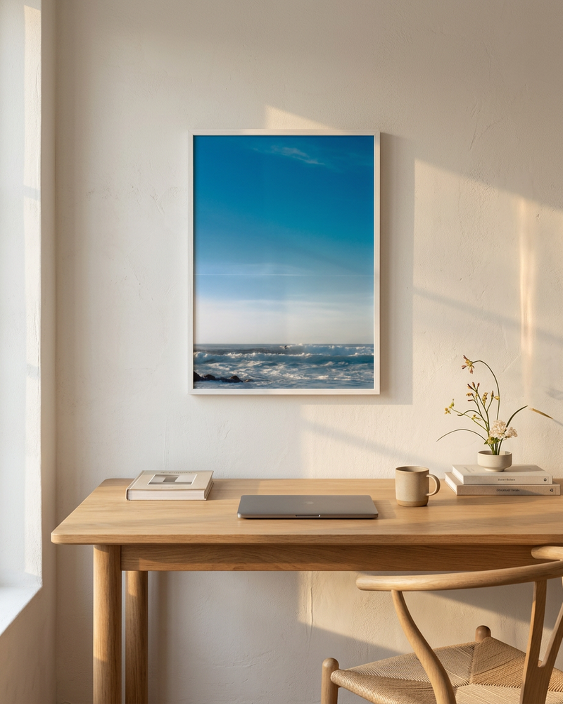 Modern office setup with a desk, chair, and minimalist fine art framed photograph on the wall.