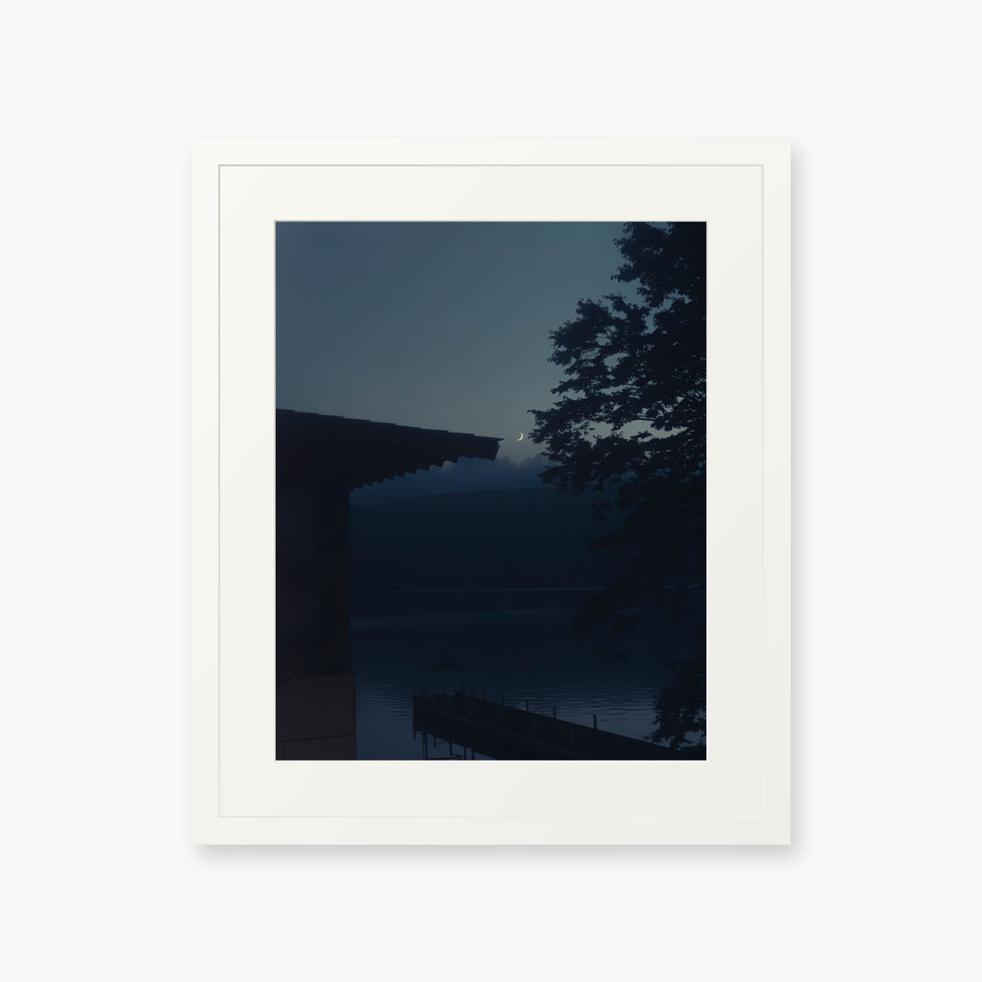 
A Daimyo’s Night — 16x20, white frame. Moon beside a dark roofline and leafy branches reflected in still water.