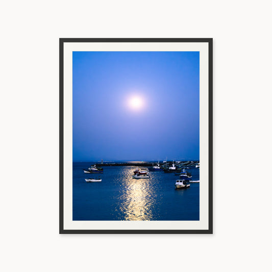 
A Faithful Guide — 30x40, black frame. Boats on deep blue water beneath a bright moon and its reflected light.