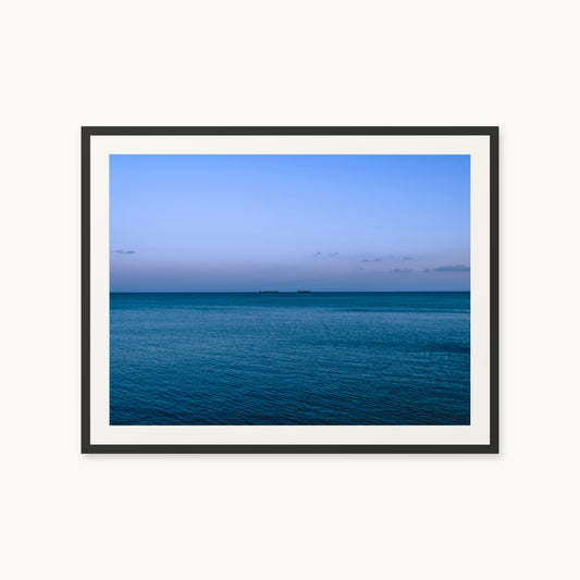 
Deux Bateaux Passants — 30x40, black frame. Two distant vessels along the horizon above a calm blue sea.