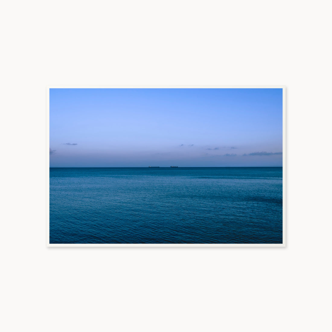 
Deux Bateaux Passants — 40x60, white frame. Two distant vessels along the horizon above a calm blue sea.