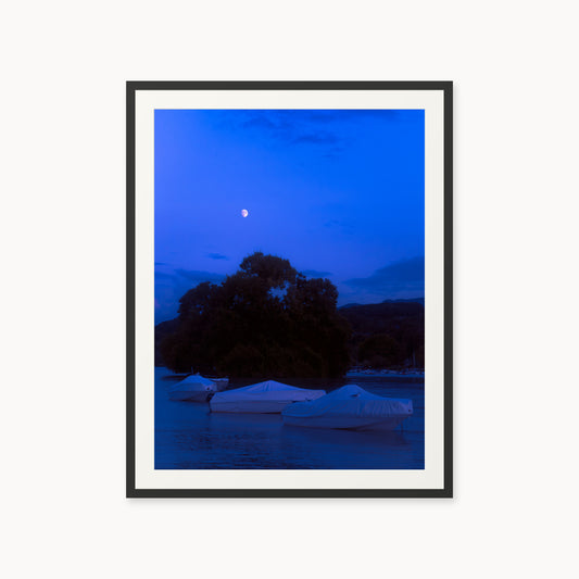 
Explorer's Rest — 30x40, black frame. Covered boats in a moonlit harbor beneath a deep blue evening sky.