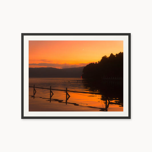 
Hour Before Nightfall — 30x40, black frame. A crescent moon above a warm sunset, dark hills, and still water.