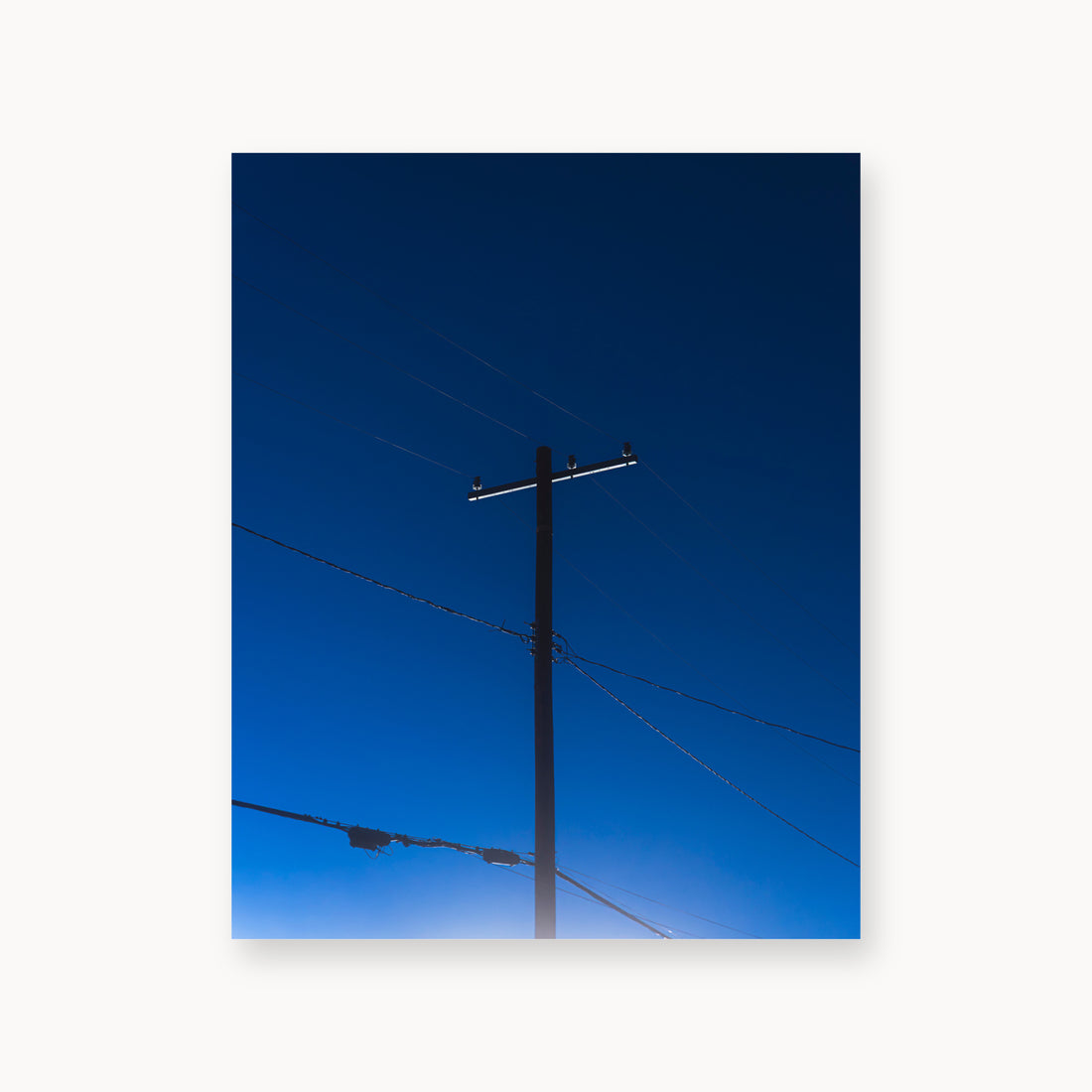 
Power — 16x20, unframed. A utility pole and crossing wires against a saturated blue evening sky.