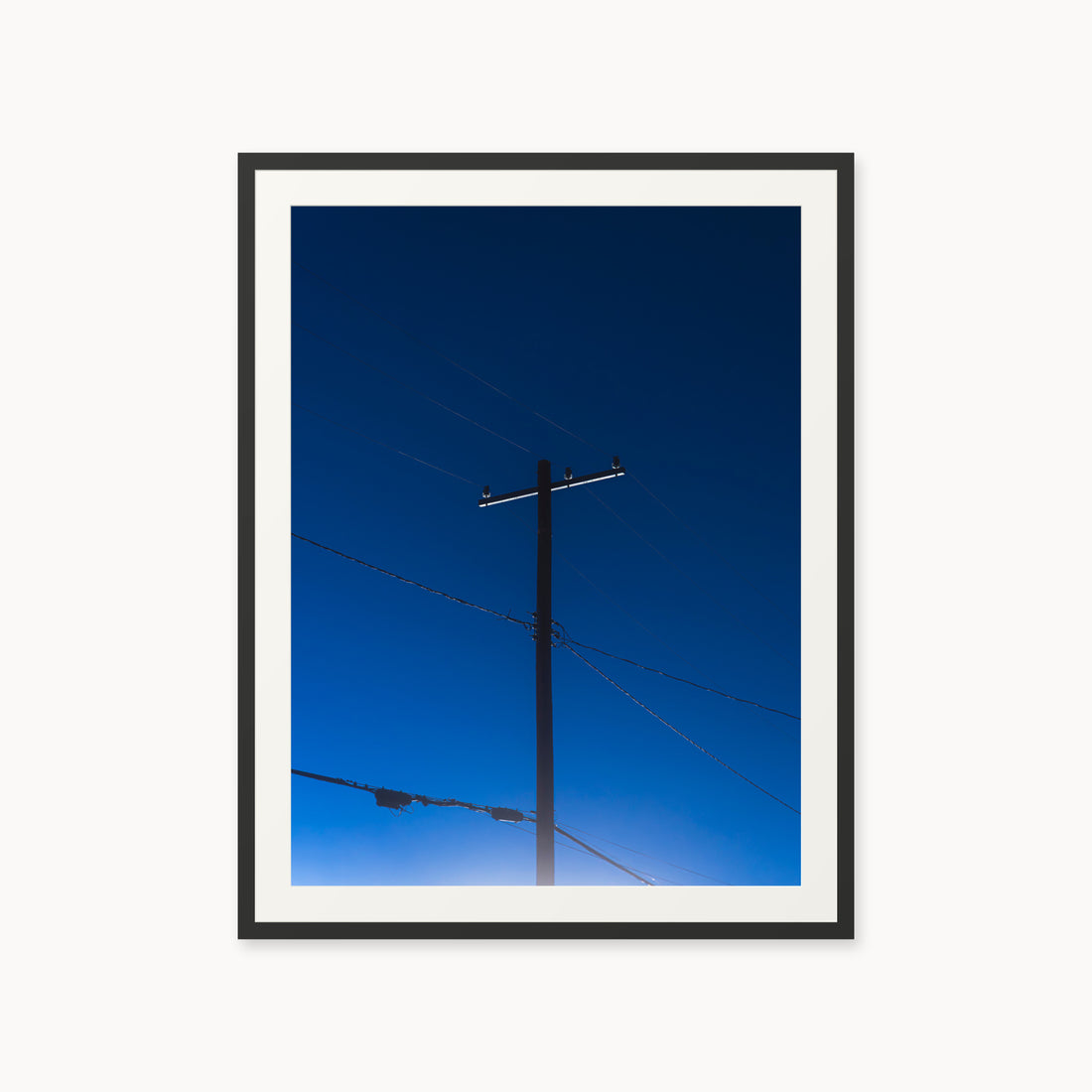 
Power — 30x40, black frame. A utility pole and crossing wires against a saturated blue evening sky.