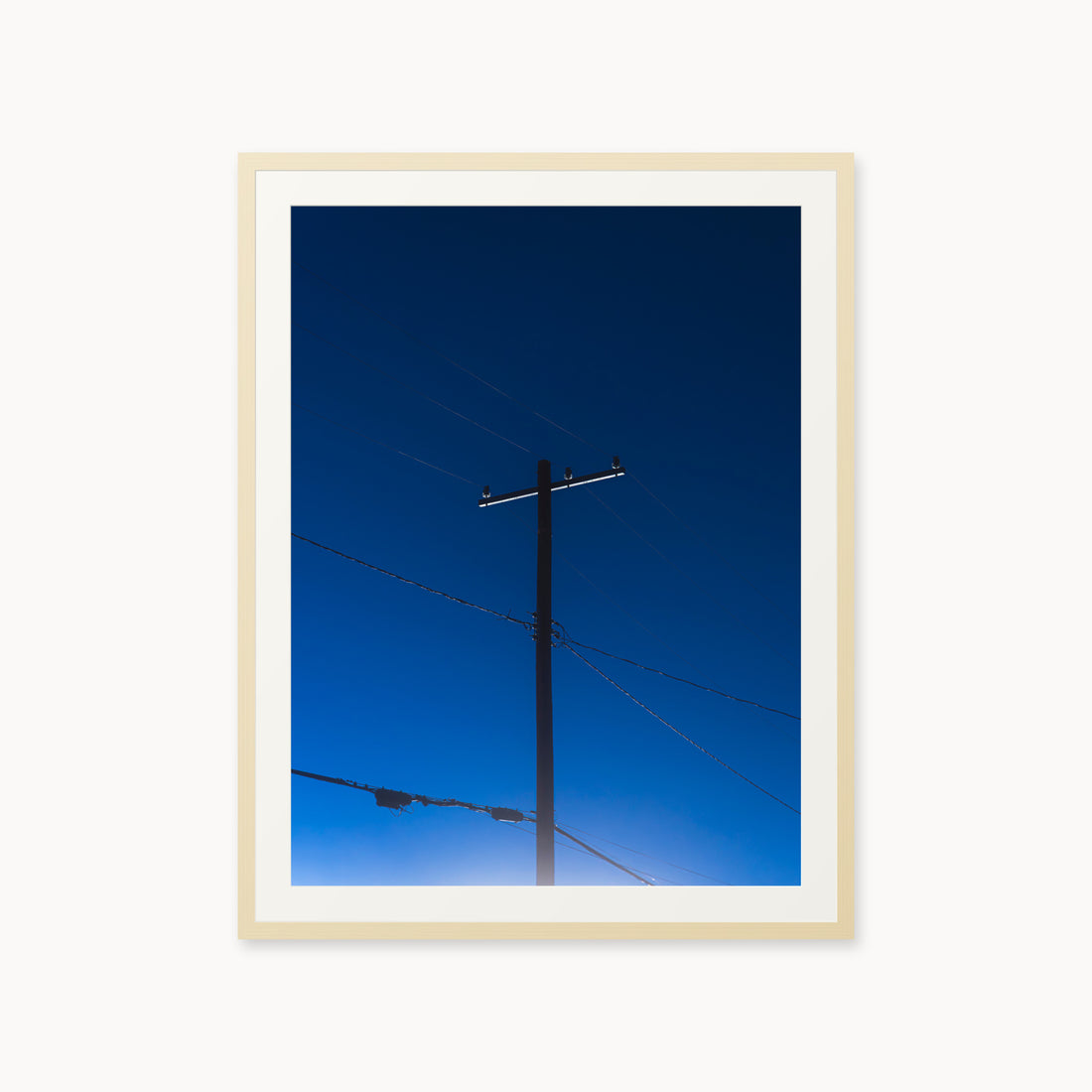 
Power — 30x40, maple frame. A utility pole and crossing wires against a saturated blue evening sky.