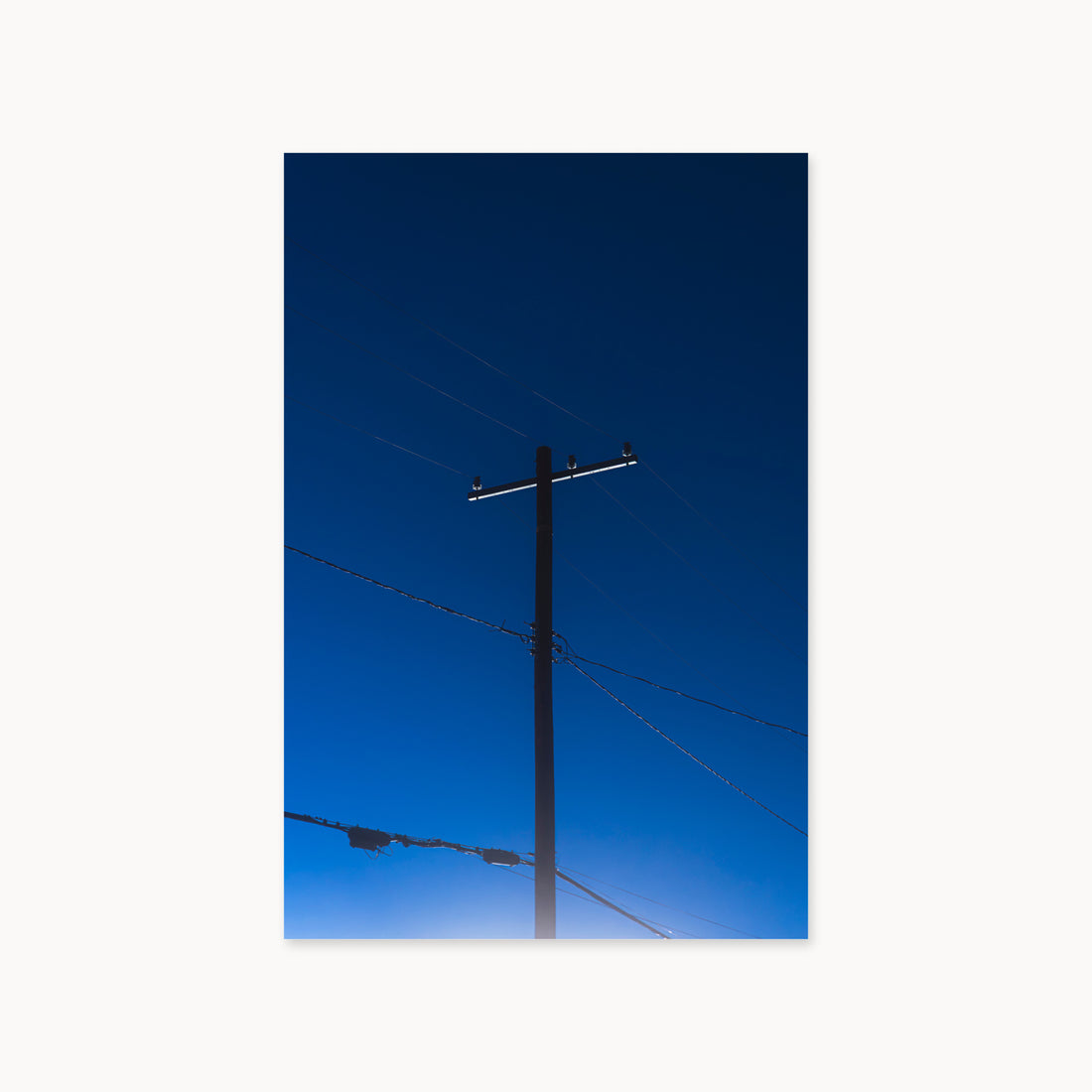 
Power — 40x60, unframed. A utility pole and crossing wires against a saturated blue evening sky.