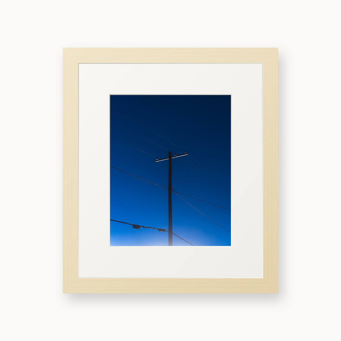 
Power — 8x10, maple frame. A utility pole and crossing wires against a saturated blue evening sky.