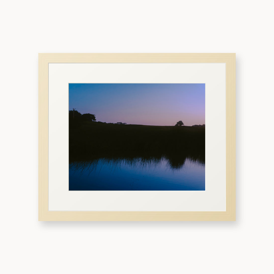 
What Lays Beneath — 11x14, maple frame. Dark trees and a twilight shoreline reflected across blue water.